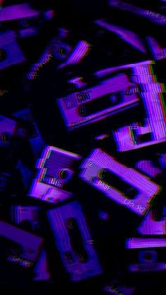 a pile of cassettes sitting on top of each other in purple and black colors