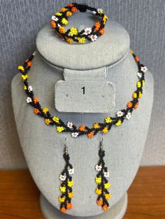 a necklace and earring set made with beads on a mannequin headdress