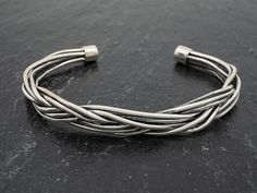 Look at the craftsman's touch in this cuff! Seven individual strands were oxidized, braided and anchored together to form this bracelet that is as striking as it is comfortable. The cuff is malleable, so it can be molded to your average size wrist. For men or women! (The choker, N4212, is pretty impressive, too!!) Adjustable Braided Cuff Bracelet, Artisan Adjustable Bangle With Oxidized Finish, Unique Adjustable Oxidized Cuff Bracelet, Adjustable Oxidized Cuff Bracelet, Strand Braid, Silver Cuff Bracelet, Cuff Bracelet, Silver Fashion, Diy Jewelry