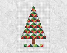 a cross stitch christmas tree with red, green and white triangles on it's side