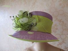 "This is a gorgeous hat in lilac straw with a yellow hat band and edging.  There is a large flower made of pale lemon and black feathers offset to the side.  Excelent condition. Circumferance of brim;  50\" Circumference of indide band;  22 1\\2\" Height of crown;  5\" Width across from tip of brim across;  15\"  X  17\" Made in France Natural straw" Spring Party Cloche Hat, Spring Wedding Wide Brim Boater Hat, Spring Curved Brim Cloche Hat For Church, Wide Brim Fascinator For Spring Garden Party, Summer Short Brim Fascinator For Garden Party, Spring Church Cloche Hat With Curved Brim, Spring Party Cloche Sun Hat, Summer Garden Party Fascinator With Short Brim, Fitted Sun Hat For Spring Weddings