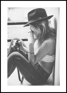 Woman sitting down smoking and holding a camera  Black and white photography of a woman wearing a hat sitting down holding a camera while smoking a cigarette. Cool poster with perfect for a gallery wall.  The poster is printed with a white margin around the image to frame the design nicely.  Artist: Magdalena Martin Ballerina Photography, Black Cowgirl, Gallery Wall Inspiration, Gold Poster, Shotting Photo, Cowgirl Aesthetic