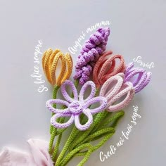 four crocheted flowers are sitting on a white surface with the words happy mama written in cursive writing