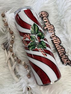 a red and white striped christmas tumbler sitting on top of a fur covered floor