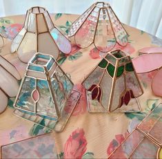 several stained glass vases sitting on top of a table