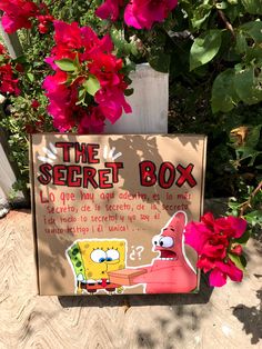 a sign that says the secret box with spongebob on it next to some flowers