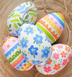 colorful painted eggs in a basket with straw