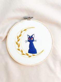 "\"Can't she think of anything other than boys and food?\" 🌙 6 inch hoop featuring Luna from Sailor Moon 🌙 Colors featured: blue & yellow 🌙 Hoop is one-of-a-kind, ready-to-ship, & comes with twine for hanging ease 🌙 Handmade with cotton fabric, cotton embroidery floss, & felt backing 🌙 Hoop ships in 1-3 business days Follow me on Instagram @shoopchoop to preview hoop designs before they drop!" Sailor Moon Embroidery, Studio Ghibli Embroidery Simple, Simple Moon Embroidery, Moon Embroidery, Boys Embroidery Designs, Embroidery Designs Studio Ghibli, Sailor Moon Embroidery Pattern, Anime Emboirdery, Sailor Moon Luna