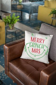 a christmas pillow sitting on top of a brown chair