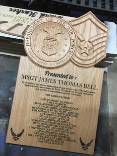 a wooden plaque with the words, names and emblems on it