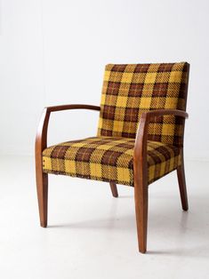 a yellow and brown plaid chair sitting on top of a white floor