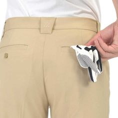 a close up of a person's pants with a glove in the pocket and one hand on his hip