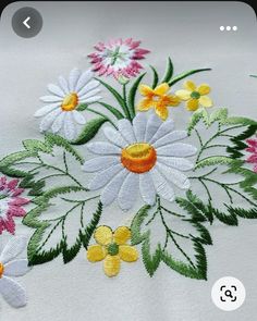 an appliqued flower design on a white shirt with green leaves and flowers