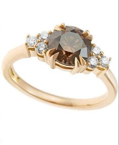 a brown and white diamond ring with two diamonds on the band, set in yellow gold