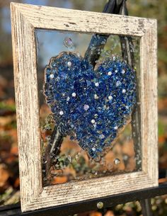 a blue heart hanging from a wooden frame