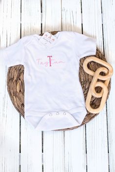 This beautifully custom embroidered 0-to-3 month short-sleeved baby bodysuit makes the perfect outfit for your new little baby girl! This comfortable and soft baby bodysuit with snaps features high quality embroidery thread that upgrades a baby one-piece! Personalized with your baby girl's name and monogram initial in beautiful script font, this summer baby clothing is a great way to celebrate your newborn's arrival. A meaningful custom baby gift new parents will love. This listing is for a custom 0-3 MONTH sized short-sleeve baby bodysuit. Buyer customization options are:  * choice of bodysuit color (oat, white) * choice of first initial and baby name  * choice of embroidery thread color (see swatch chart in listing photos) Please allow 1-3 business days processing time from date of order Personalized Fitted White Bodysuit, White Personalized Short Sleeve Onesie, Fitted Short Sleeve Onesie With Name Print, Cotton Onesie For Baptism, Cotton Short Sleeve Onesie For First Birthday, White Short Sleeve Onesie For First Birthday, Cotton Baptism Onesie With Short Sleeves, Personalized Fitted Short Sleeve Onesie, White Short Sleeve Onesie For Baptism