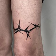 a tattoo on the leg of a person with barbed wire