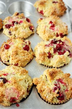 freshly baked muffins with cranberry toppings on a baking tray ready to be eaten