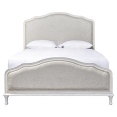 the headboard and foot board of a bed with white linens on top of it