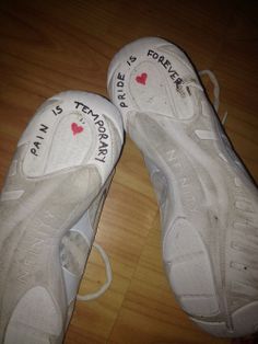 two pairs of white tennis shoes with writing on the soles that say i love you