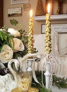 two candles are sitting on a table with flowers