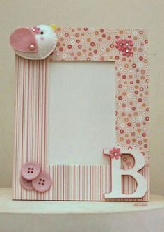 a pink and white photo frame with a hello kitty decoration on the top, along with buttons