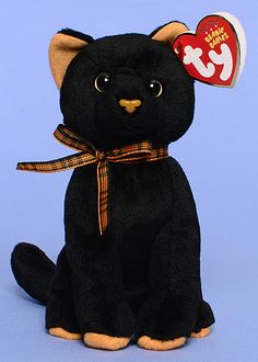 a black stuffed cat with a tag on its ear sitting in front of a blue background