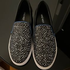 Never Worn. No Box. Nine West Slip-On Shoes/Sneakers. Gray, Black, And White Speckled Pattern With Blue Piping. Two Spots Of Slight Discoloration On The Sole/Bottom Though Never Worn. Also, Very Slight Mark On Right Heel Shown In Last Picture. Black Slip-on Sneakers With Speckled Midsole, Casual Black Slip-on Sneakers With Speckled Midsole, Nine West Shoes, Nine West, Womens Shoes Sneakers, On Shoes, Slip On Shoes, Piping, Black Gray