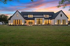 a large white house sitting on top of a lush green field