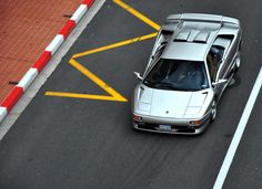 a white sports car driving down the road