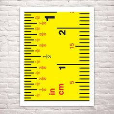 a yellow and red ruler on a brick wall