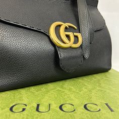 Le sac Gucci Marmont en cuir grainé noir est un accessoire de luxe distinctif. Ce dernier est doté d'une bandoulière en cuir noir, ajustable et amovible. L'intérieur est spacieux et bien organisé. Ce sac est à la fois élégant et fonctionnel, ajoutant une touche sophistiquée à toute tenue. • État : B - Très bon • Dimensions : 32.5x21x14cm • Matière : Cuir grainé • Couleur : Noir • Vendu avec : Dust Designer Shoulder Bag With Cc Turnlock For Business, Leather Shoulder Bag With Cc Turnlock And Top Handle, Elegant Black Satchel With Cc Turnlock Closure, Business Shoulder Bag With Pebbled Leather And Branded Hardware, Business Shoulder Bag With Branded Hardware In Pebbled Leather, Business Shoulder Bag With Branded Hardware And Pebbled Leather, Black Pebbled Leather Shoulder Bag For Business, Designer Pebbled Leather Shoulder Bag, Luxury Pebbled Leather Shoulder Bag With Branded Hardware