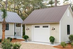 two garages in front of trees and bushes