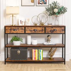 a wooden shelf with two drawers and some books on it next to a wall with pictures