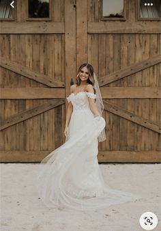 a woman standing in front of a wooden door wearing a white wedding dress and veil