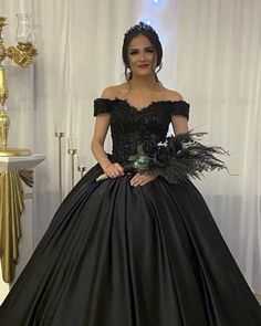 a woman in a black ball gown holding a bouquet