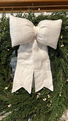 a christmas wreath with white bows hanging from it