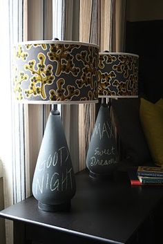 three vases sitting on top of a table next to a lamp