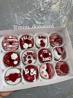 a box filled with lots of red and white cupcakes