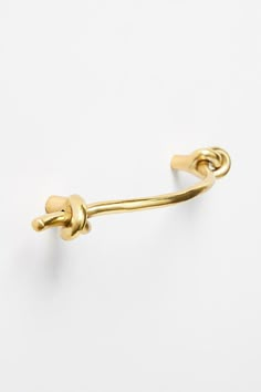 a pair of gold - plated hooks on a white background