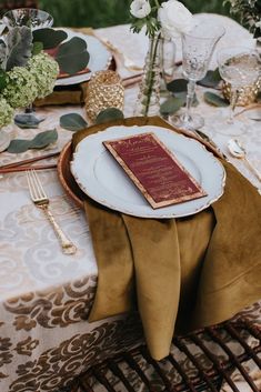 a table set with plates, silverware and napkins for an elegant wedding reception