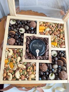 a wooden box filled with assorted chocolates and nuts