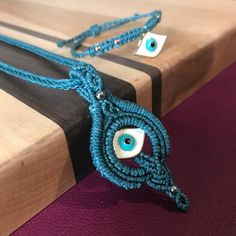 two blue macrame cords with an evil eye on them