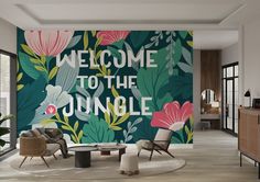 a living room with a wall mural that says welcome to the jungle