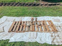 a wooden pallet sitting on top of a blanket in the grass