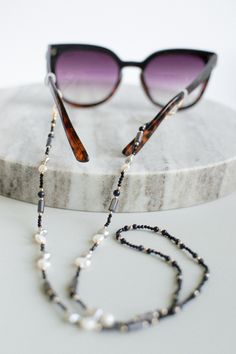 White and Silvery pearl glasses chain with Gold plated 925 Sterling silver parts and beads. Ideal Summer Sunglasses accessory jewellery. Can be a great gift for anyone who wears sunglasses or optical glasses. Chain lengths is 36 cm and full lengths is 72 cm. Pearl chain comes with black and white attaching rubber bands and is packed in a black cardboard box. Unique design. Handmade. Instagram: https://www.instagram.com/dextella.accessories/ Elegant Glass Jewelry With Pearl Chain, Elegant Black Beaded Glasses Chains, Party Pearl Glasses Chain, Handmade Elegant Glasses Chains With Round Beads, Elegant Handmade Round Beads Glasses Chains, Elegant Beaded Glass Chain For Glasses, Elegant Pearl Chain Glasses Chains As Gift, Elegant Glass Beaded Glasses Chain, Elegant Pearl Glasses Chain As Gift