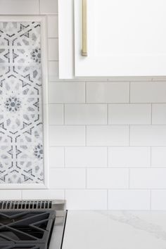 a stove top oven sitting inside of a kitchen next to a white tiled counter top