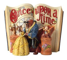 an open book with figurines of disney characters