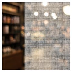 blurry image of shelves in a store with lights coming from the window behind them