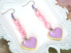 Pride Month Sale! Discount: 20% off when you buy 2 items + free pride themed jewelry gift! Promo code: HAPPYPRIDEMONTH Radiate kawaii charm with these adorable Pixel Heart Cookie Dangle Earrings, inspired by the vibrant and playful aesthetics of Harajuku and Decora Kei styles in Japanese fashion. These earrings are a delightful fusion of cuteness and creativity, perfect for those who love to make a sweet statement. Crafted with attention to detail, each earring features a colorful pixelated heart-shaped cookie that dangles elegantly, adding a touch of whimsy to any outfit. Embrace your inner style icon and add a fun twist to your look with these unique accessories that capture the essence of Harajuku fashion. Elevate your accessory game with these Pixel Heart Cookie Dangle Earrings and let Cute Dangle Earrings With Heart Charm, Cute Purple Jewelry With Heart Charm, Handmade Kawaii Earrings For Valentine's Day, Cute Heart Dangle Earrings With Ear Wire, Cute Dangle Heart Earrings With Ear Wire, Cute Handmade Dangle Heart Earrings, Cute Handmade Heart Dangle Earrings, Cute Pink Pierced Heart Earrings, Cute Pink Heart Pierced Earrings